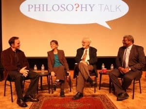 Four people discuss the philosophy of retirement at a panel discussion.