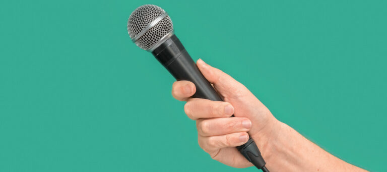 Close-up of a hand holding a microphone.