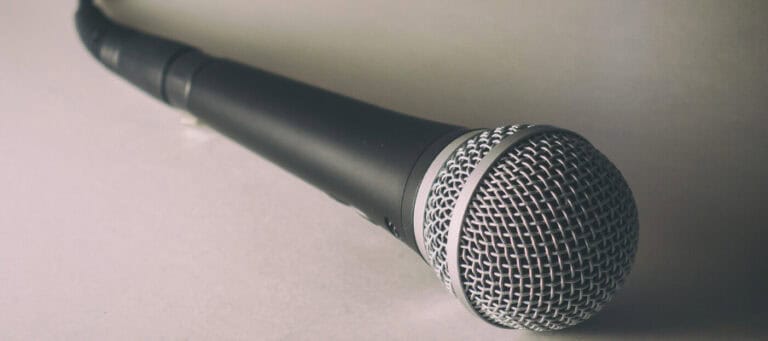 Close-up of a black microphone on a white surface.