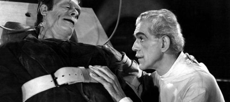 Close-up of Colin Clive as Henry Frankenstein examining Boris Karloff as Frankenstein's monster.