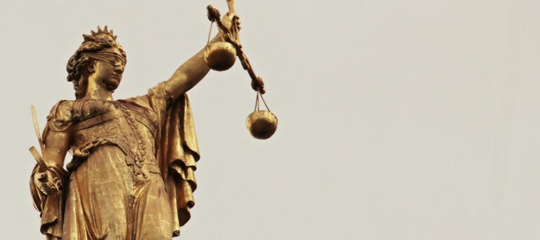 Golden statue of Lady Justice, blindfolded, holding scales of justice.