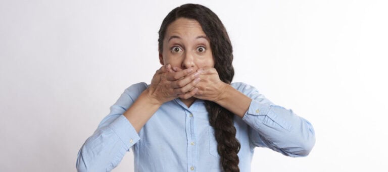 Woman covering her mouth in shock or surprise.