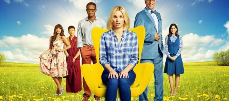 The cast of The Good Place poses in a field. Kristen Bell sits in a yellow chair.