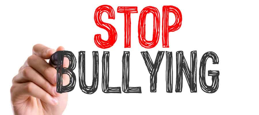 Hand writing 'STOP BULLYING' with a marker.