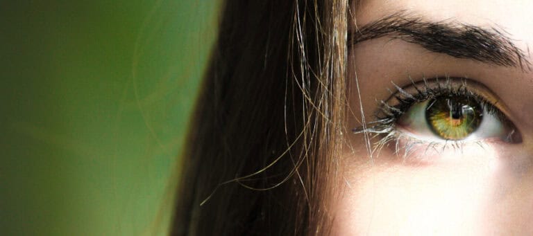 Close-up of a woman's eye, showcasing striking green iris.