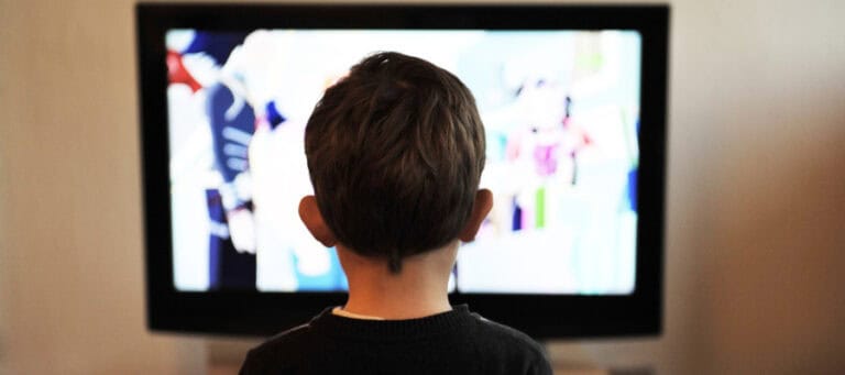 Child watching television, back view.