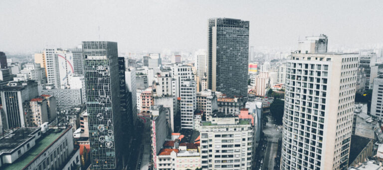 High-angle view of a dense cityscape. Buildings of varying heights and architectural styles.