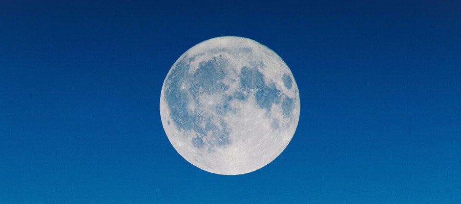 Full moon in a clear blue sky.
