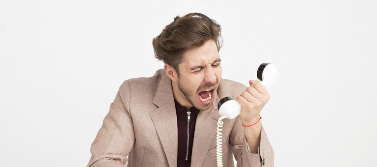 Angry man yelling into vintage phone