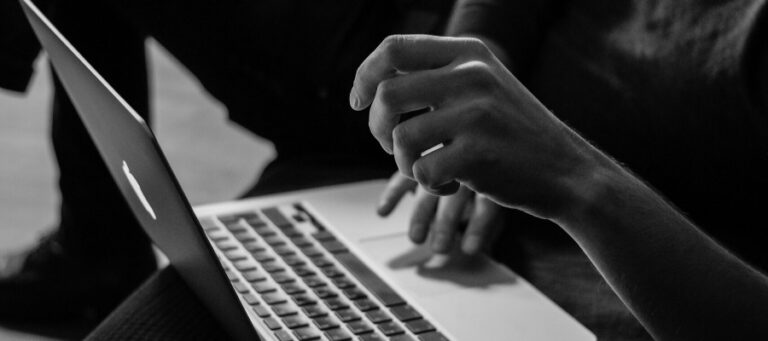 Person's hands using a laptop, reflecting on philosophical concepts.