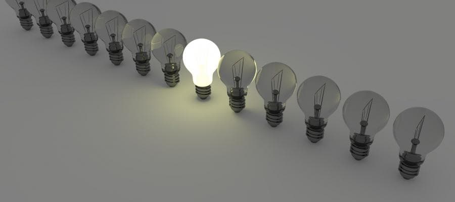 Line of lightbulbs, one glowing brightly; concept of unique idea.
