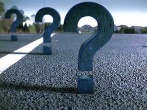 Large question marks stand on a street, symbolizing discrimination.