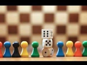 Colorful game pieces line up before stacked dice; a game in progress.