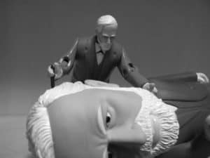 Figurines depicting a doctor examining a patient, possibly illustrating a shift in psychological treatment beyond Freudian methods.