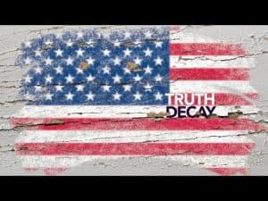 Faded American flag on weathered wood; text overlay: "Truth Decay