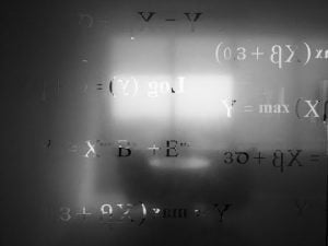 Equations and formulas on a frosted glass surface, illustrating the timeless nature of mathematics.