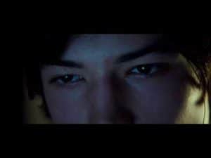 Close-up of a young man's intense gaze, reflecting a strange desire.