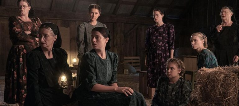 Group of women in Amish-style clothing gathered in a barn. A lost republic's dream?