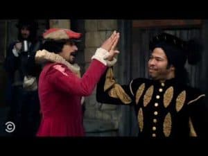 Two men in 16th-century attire give a high five. Shakespeare's outsiders.
