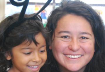 Happy teacher and young student smiling together