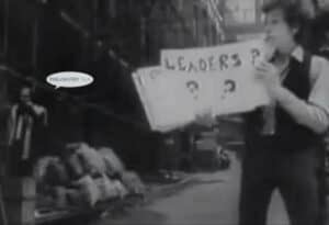 Person holding a sign asking "Leaders?