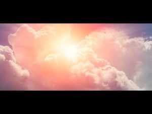 Bright sun shining through fluffy clouds.