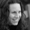 Black and white headshot of a smiling woman.