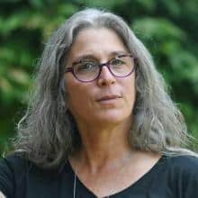Headshot of a woman with gray hair and glasses, advocating for animal rights.