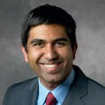 Headshot of a smiling man in a suit