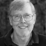 Black and white headshot of a man wearing glasses