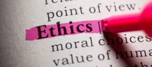 Close-up of dictionary definition of "Ethics," highlighted with pink marker; related to moral choices and human values.