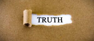 Torn paper revealing the word TRUTH. The value of truth.
