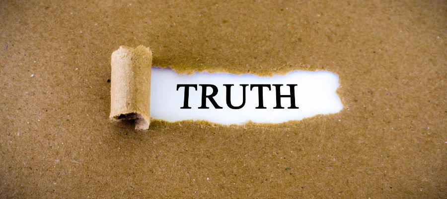 Torn paper revealing the word TRUTH. The value of truth.