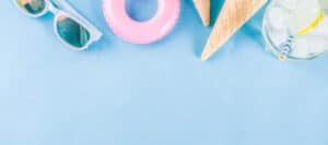 Summer essentials: sunglasses, inflatable ring, ice cream cones, and a refreshing drink.