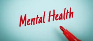 Red marker writing "Mental Health" on a blue background.