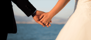 Newlyweds holding hands, symbolizing marriage and commitment.