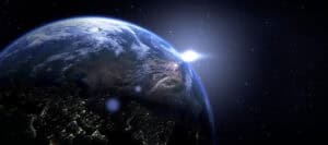 Earth from space, sun rising over landmasses. Global perspective.