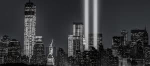 New York City skyline at night, illuminated with Tribute in Light, honoring victims of terrorism.