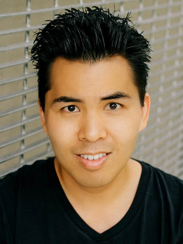 Headshot of a man with short, dark hair against a metal background.