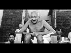 Gandhi, seated, contemplative expression. Philosophical leader of India's independence movement.