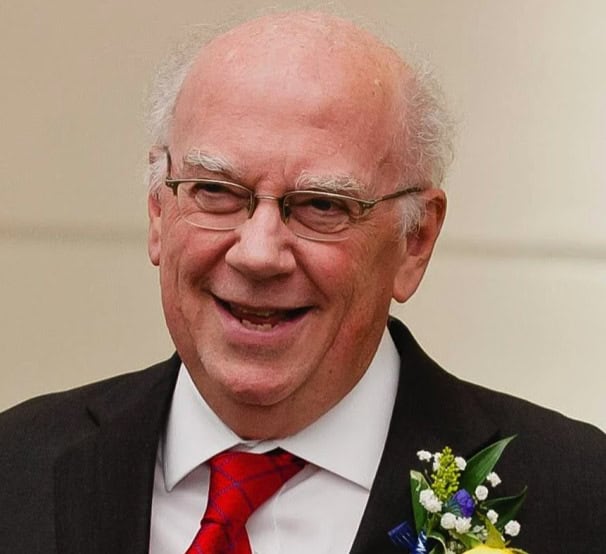 Professor smiling, wearing glasses and a red tie; Philosophy of History