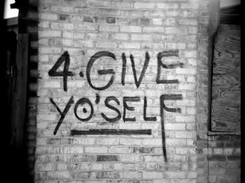 Graffiti on a brick wall reads: "4-Give Yo'Self