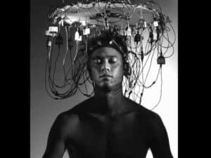 Man with electrodes on his head, undergoing brainwave monitoring for mind enhancement.