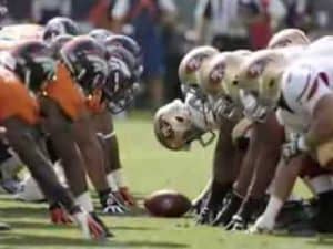 Two football teams lined up, ready to act together on the field.