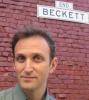 Man standing in front of a Beckett street sign.
