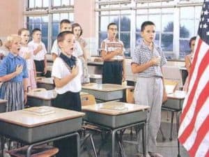 Students reciting the Pledge of Allegiance in a 1950s classroom. Education and culture wars.