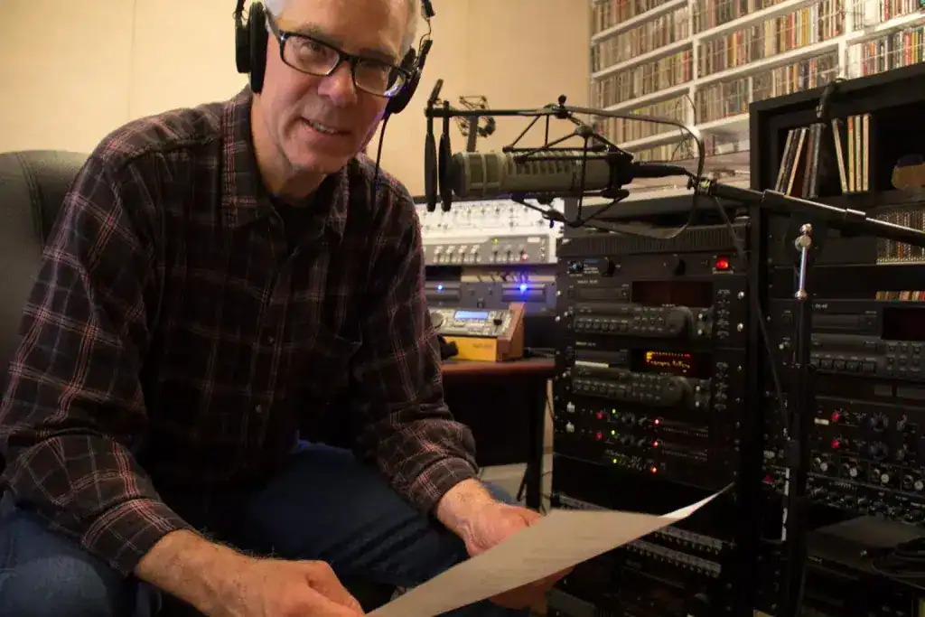 Man in headphones at audio recording studio console