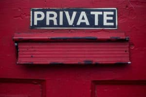Red door with "PRIVATE" sign and weathered mailbox