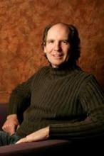 Headshot of a middle-aged man with receding hairline, wearing a dark turtleneck sweater.