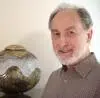 Portrait of a man, smiling, with a ceramic vase.